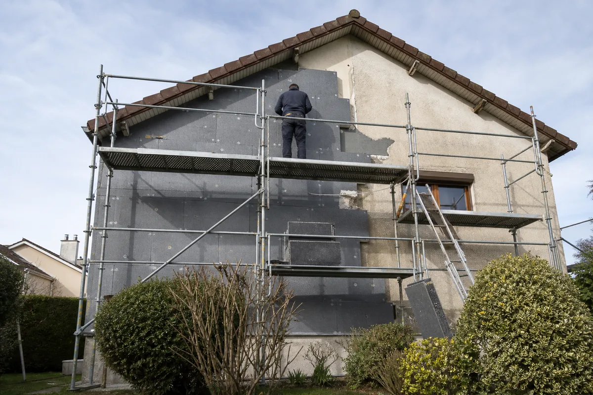 Façade de pavillon francilien en cours d’isolation par l’extérieur, panneaux isolants posés sous échafaudage