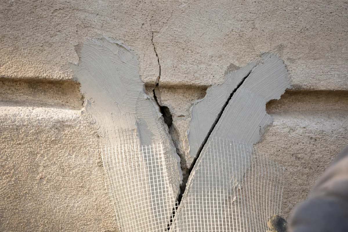 Façadier appliquant un enduit taloché sur un pavillon du Val-d&rsquo;Oise depuis un échafaudage