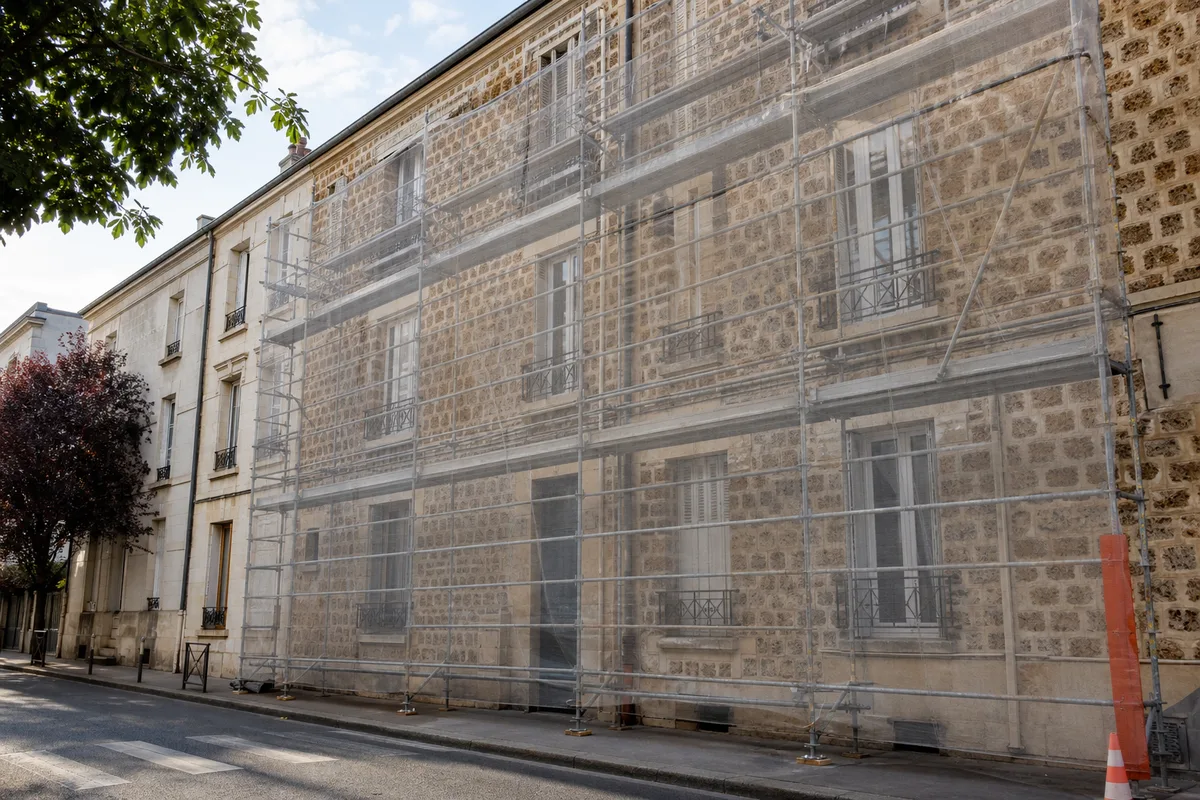 Échafaudage monté sur la façade en meulière d&rsquo;un immeuble ancien du Val-d&rsquo;Oise
